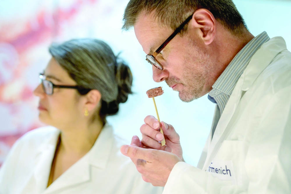 Flavorists Liliana Favaron (L) and Mark Rubin taste a vegetal steak at the headquarters of Swiss group Firmenich, in Satigny near Geneva. - AFP
