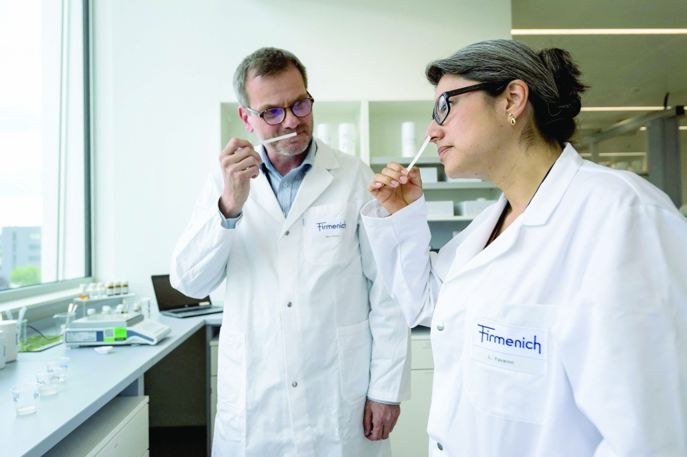 Flavorists Liliana Favaron (R) and Mark Rubin smell a combination of fragrances at the headquarters of Swiss group Firmenich in Satigny near Geneva. - AFP