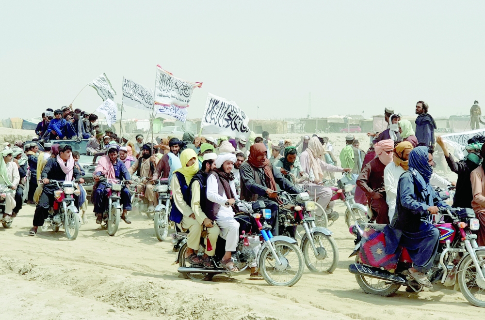 People on vehicles, holding Taliban flags, gather near the Friendship Gate crossing point in the Pakistan-Afghanistan border town of Chaman, Pakistan, on Wednesday. -- Reuters