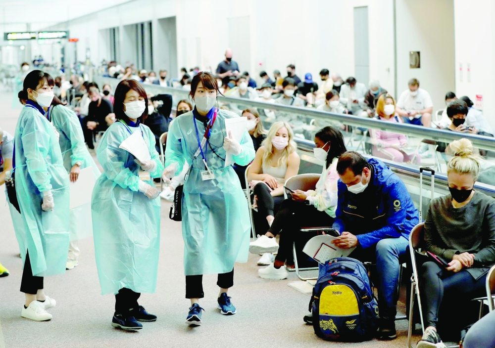 Officials wearing personal protection equipment (PPE) prepare to administer the quantitative coronavirus disease antigen test to the members of the US gymnastics team at Narita International Airport ahead of Tokyo 2020 Olympic Games, in Narita, east of Tokyo, on Thursday. -- Reuters