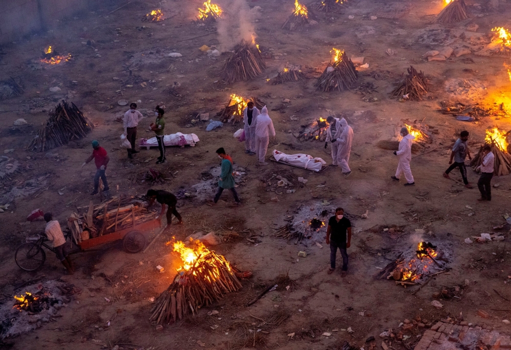 FILE PHOTO: People wait to cremate COVID-19 victims at a crematorium ground in New Delhi