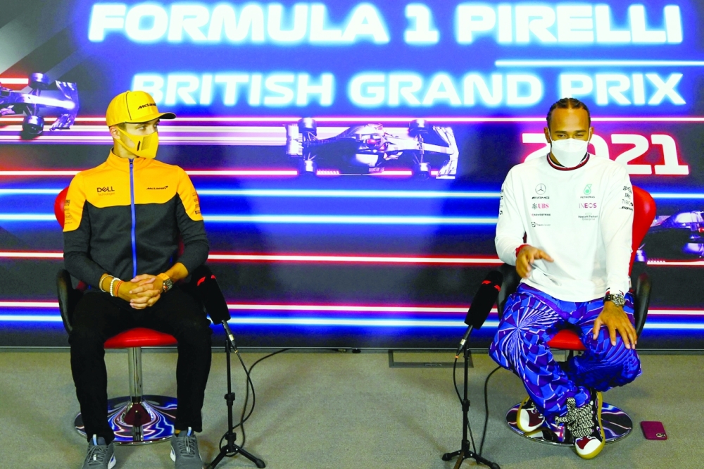 McLaren's British driver Lando Norris (L) and Mercedes' Lewis Hamilton gesture during a press conference. -- AFP