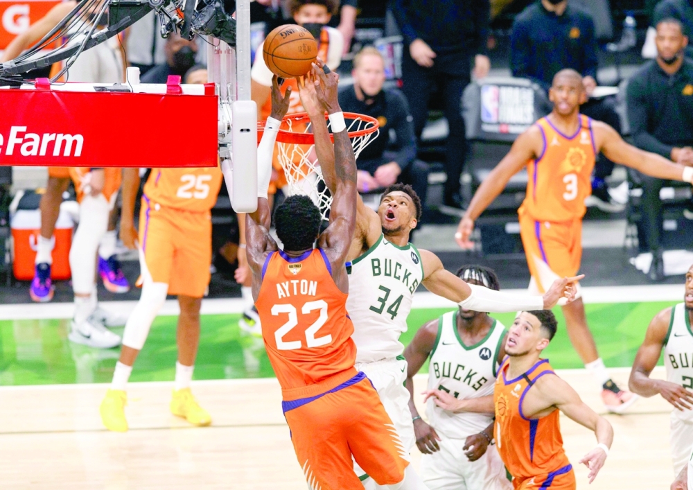 Milwaukee Bucks forward Giannis Antetokounmpo (34) defends Phoenix Suns center Deandre Ayton (22). -- USA Today Sports