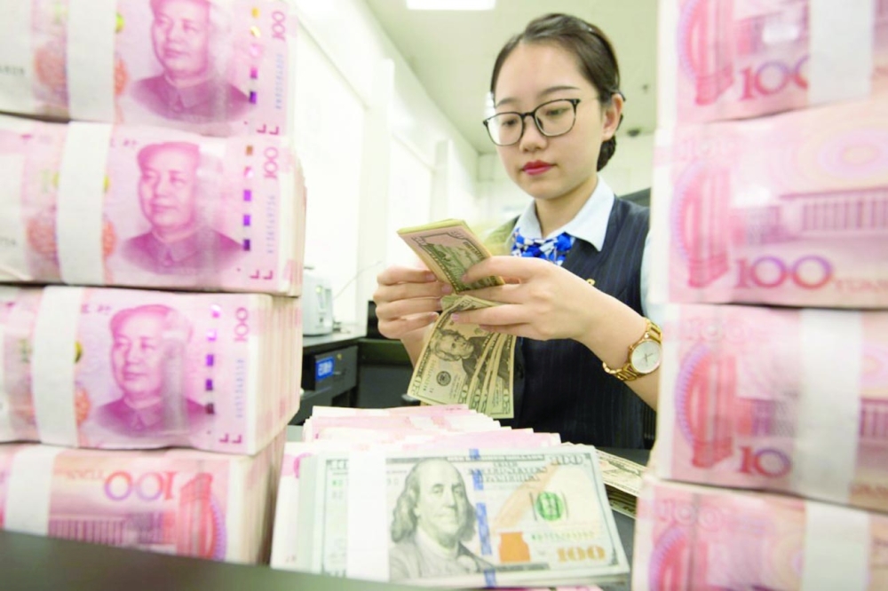 A woman is seen counting US dollars inside a bank in Hangzhou, Zhejiang province, China. — Reuters