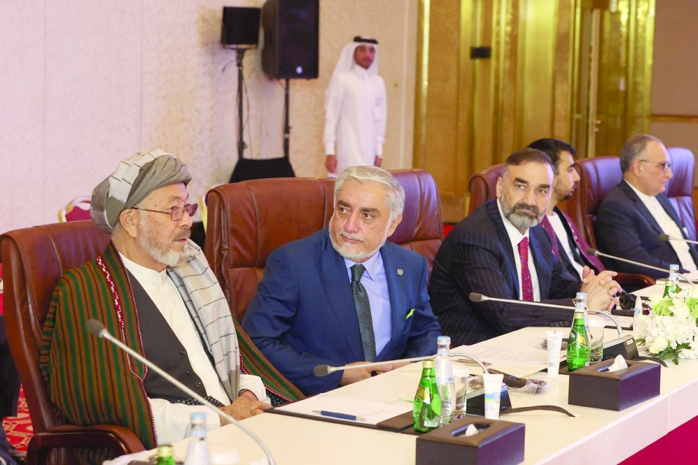 Afghanistan's former chief executive Abdullah Abdullah (2nd L) attends a session of the peace talks between the Afghan government and the Taliban in the Qatari capital Doha, on Saturday. (Right) A delegation of Taliban movement attends the peace talks. - AFP 