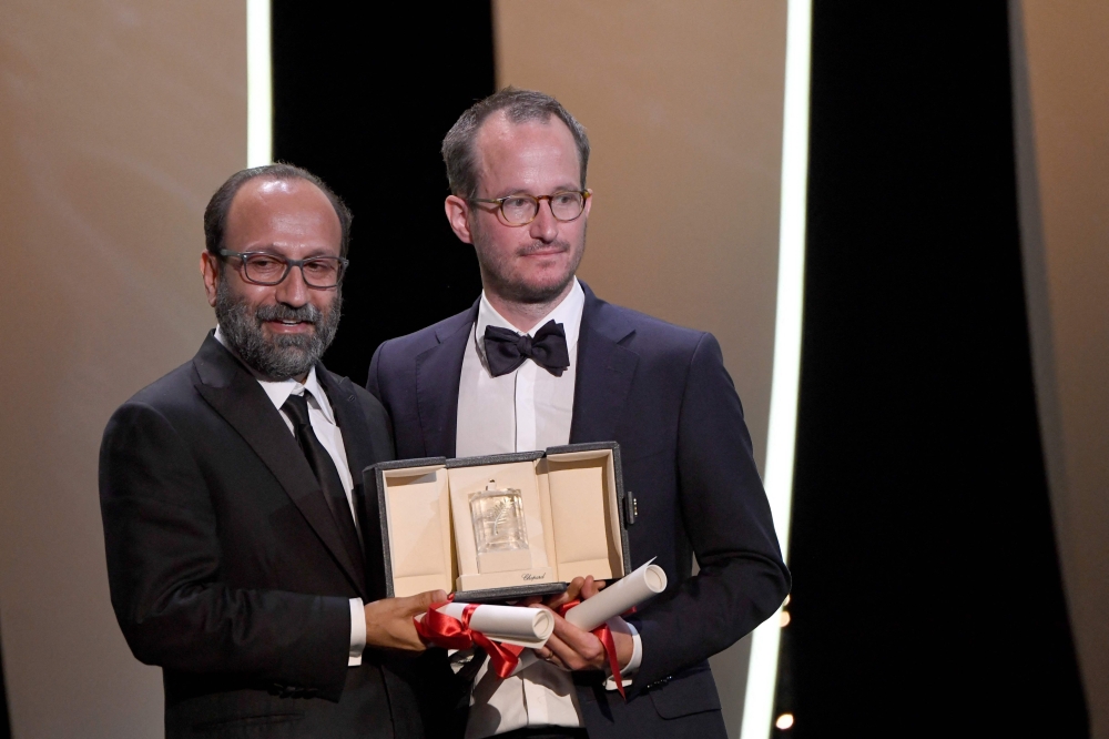 Iranian director Asghar Farhadi (L) and Finnish director Juho Kuosmanen pose on stage 