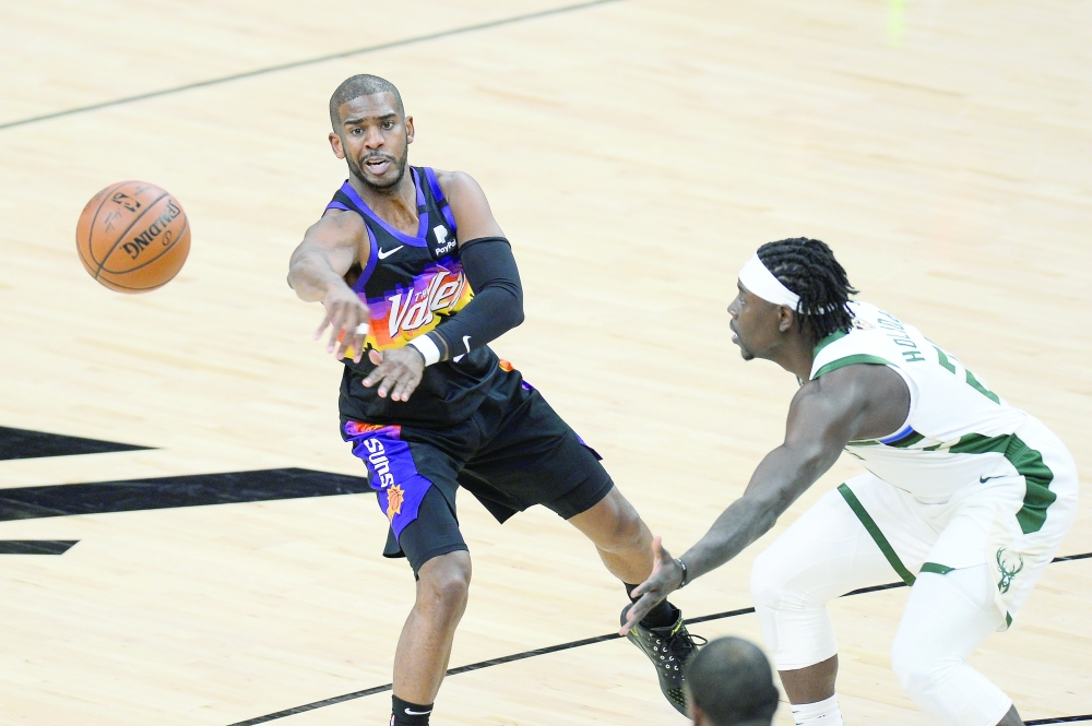 Phoenix Suns guard Chris Paul (3) passes the ball in front of Milwaukee Bucks guard Jrue Holiday (21) during game five of the 2021 NBA Finals. -- USA Today Sports

