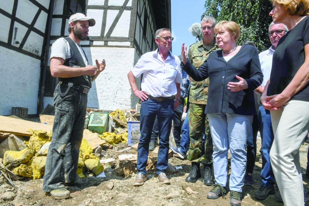 German Chancellor Angela Merkel and Rhineland-Palatinate State Premier Malu Dreyer talk to a resident during their visit in the flood-ravaged village of Schuld near Bad Neuenahr-Ahrweiler, western Germany. - AFP