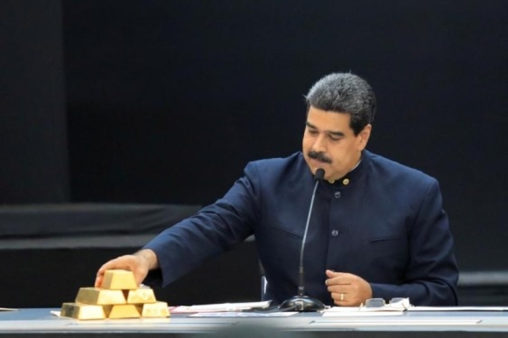 Venezuela's President Nicolas Maduro touches a gold bar as he speaks at Miraflores Palace in Caracas. — Reuters
