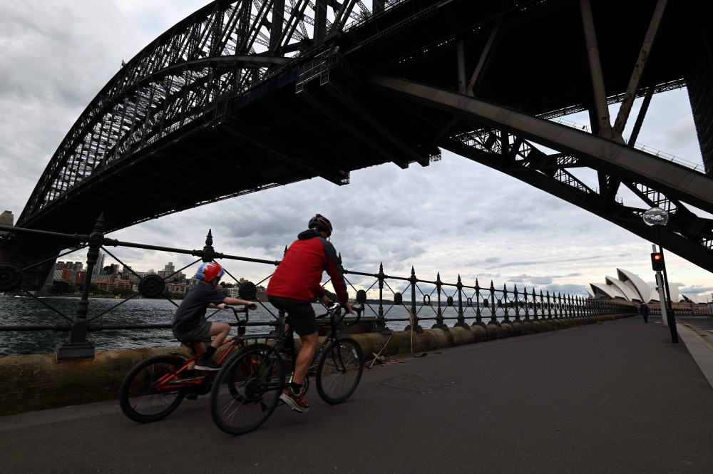 Cyclists ride through the quiet walkway along Harbour Bridge in Sydney as about 12 million people are under lockdown in Melbourne and Sydney. - AFP 