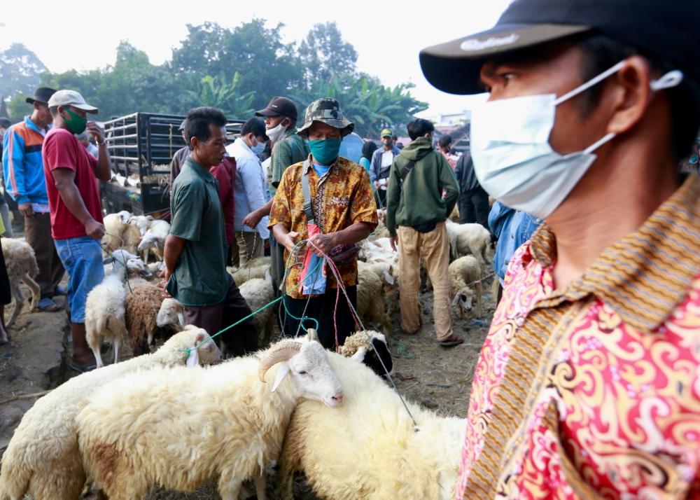 People sell sheeps and goats at a cattle market, ahead of Eid al Adha in Bogor, on the outskirts of Jakarta, Indonesia. - Reuters
