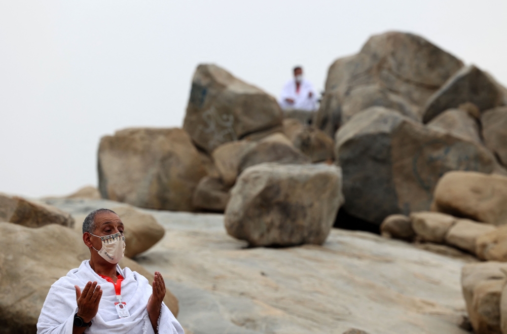 Pilgrims pray next to Mount Arafat, southeast of the holy city of Mecca, during the climax of the Haj pilgrimage amid the Covid-19 pandemic, on Monday. - AFP