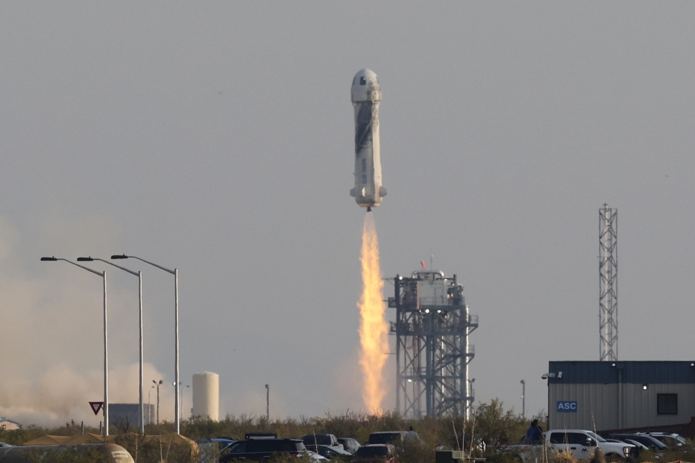 Billionaire businessman Jeff Bezos is launched with three crew members aboard Blue Origin's New Shepard rocket