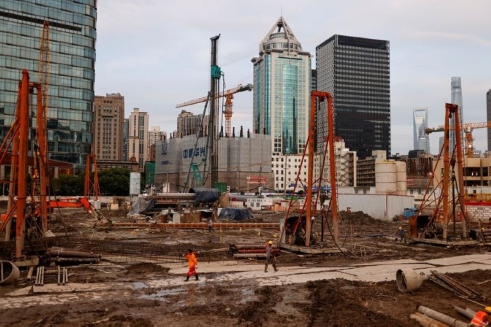 Labourers work at a construction site in Shanghai, China. — Reuters