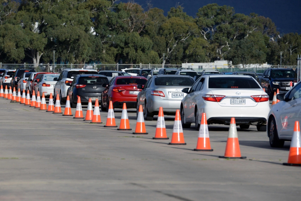 People queue in their vehicles at the Victoria Park Covid-19 testing station in Adelaide after local coronavirus cases were detected. - AFP 