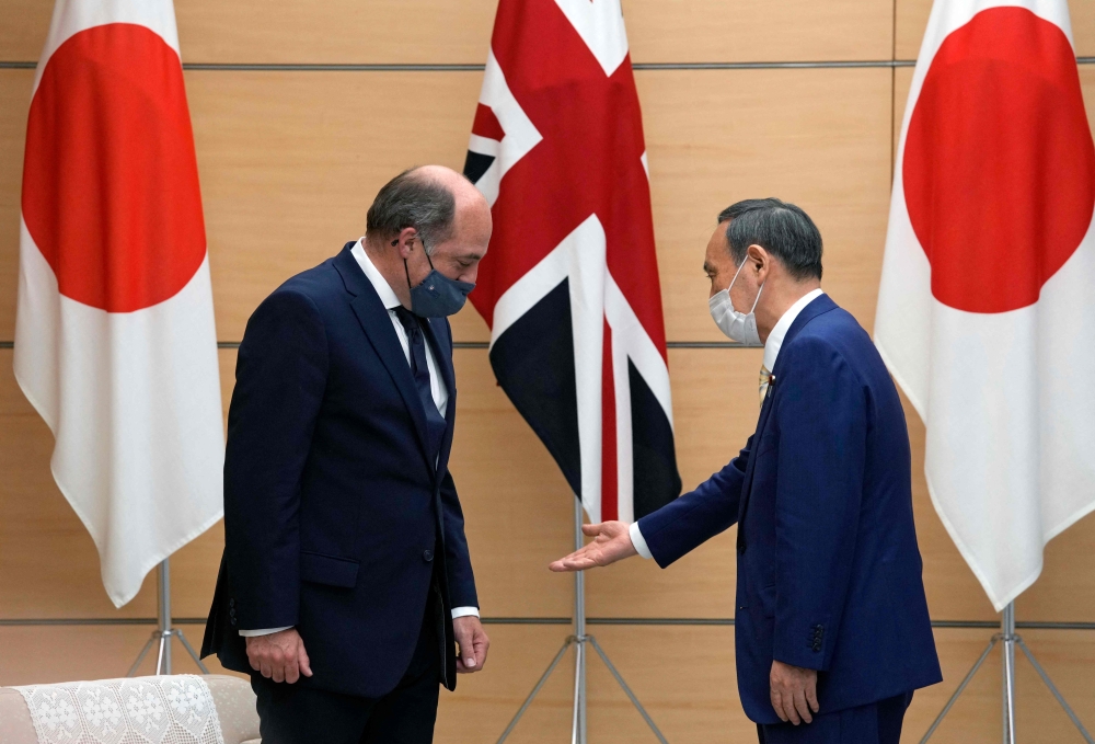 Britain's Defence Secretary Ben Wallace is welcomed by Japan's Prime Minister Yoshihide Suga at the prime minister's official residence in Tokyo. - AFP

