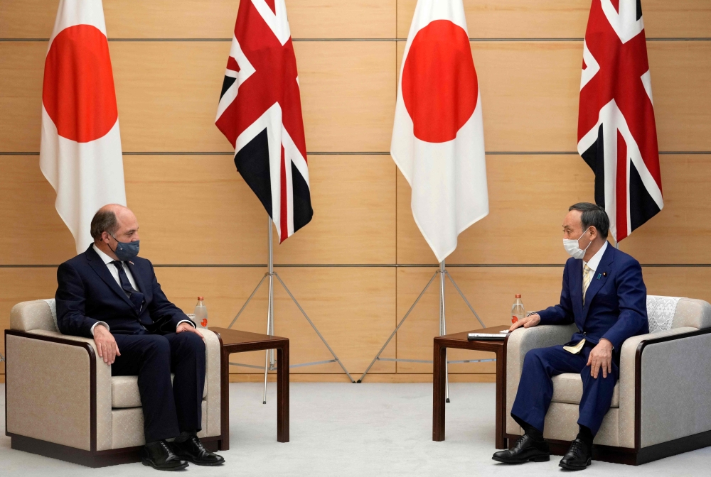 Britain's Defence Secretary Ben Wallace with Japan's Prime Minister Yoshihide Suga during their meeting in Tokyo.-  AFP

