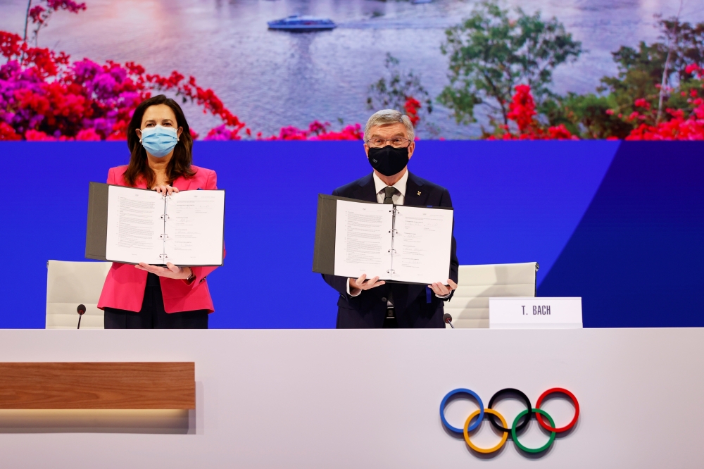 Annastacia Palaszczuk MP, Premier of Queensland and IOC President Thomas Bach hold up copies of the Host Agreement after Brisbane was announced as the 2032 Summer Olympics host city during the 138th IOC session in Tokyo. -- Reuters