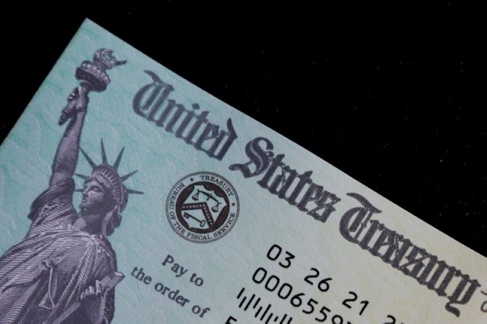 A family’s stimulus check from the US Treasury for Covid-19 aid arrived in the mail in Milton, Massachusetts. — Reuters