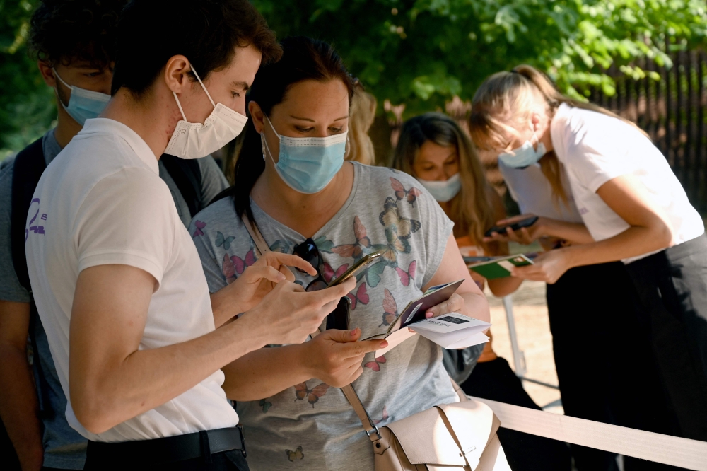 Employees of the Eiffel Tower check clients' health passes before they visit the Eiffel Tower in Paris. - AFP 