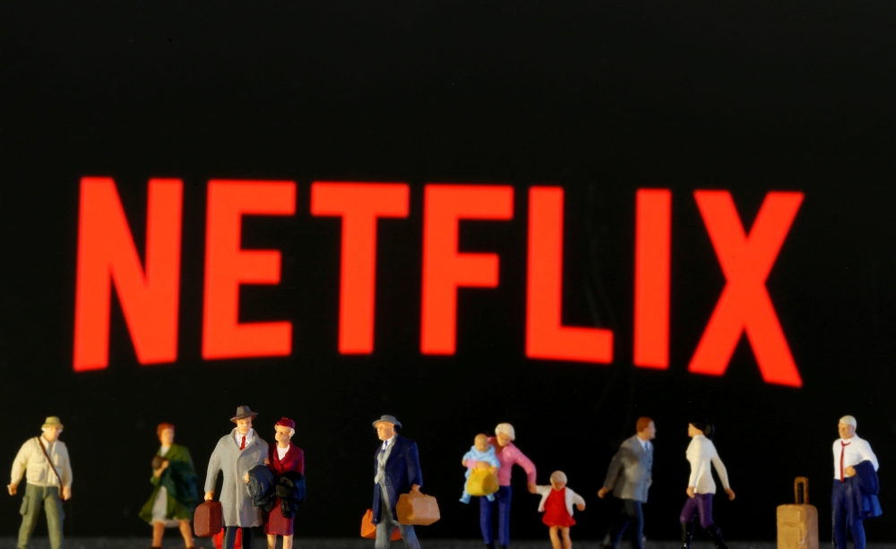 Small toy figures are seen in front of displayed Netflix logo in this illustration. - Reuters 