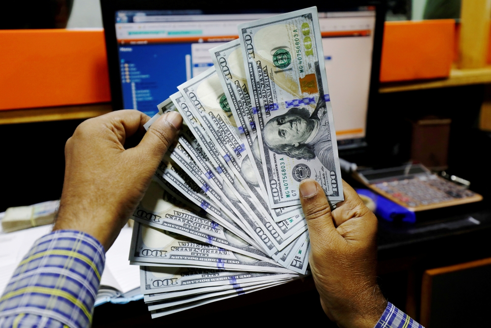 A trader shows US dollar notes at a currency exchange booth in Karachi. - Reuters File Photo 