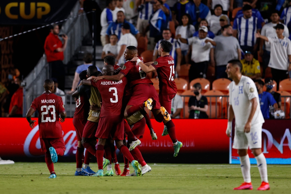 Qatar players celebrate after Abdelaziz Hatim scored a goal against Honduras during the Gold Cup in Houston. -- AFP