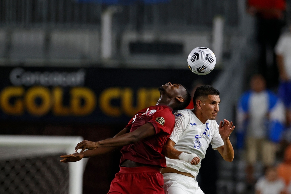 Qatar's Mohammed Muntari (L) and Honduras' Johnny Leveron go for a header. -- AFP 