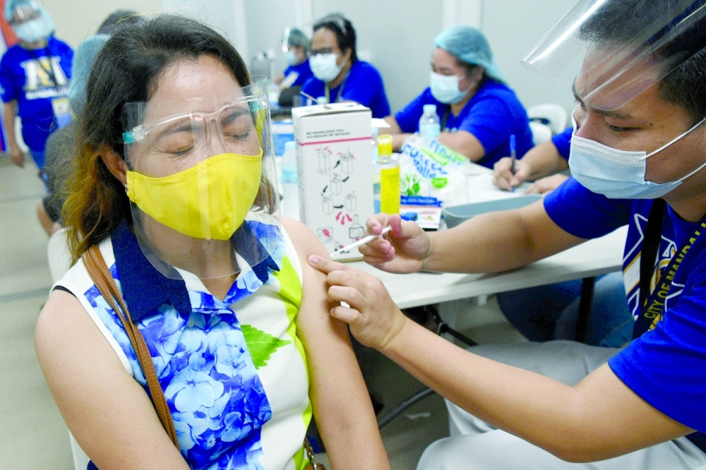 A woman receiving a Covid jab at a vaccination centre in Mandaluyong in suburban Manila. - AFP 