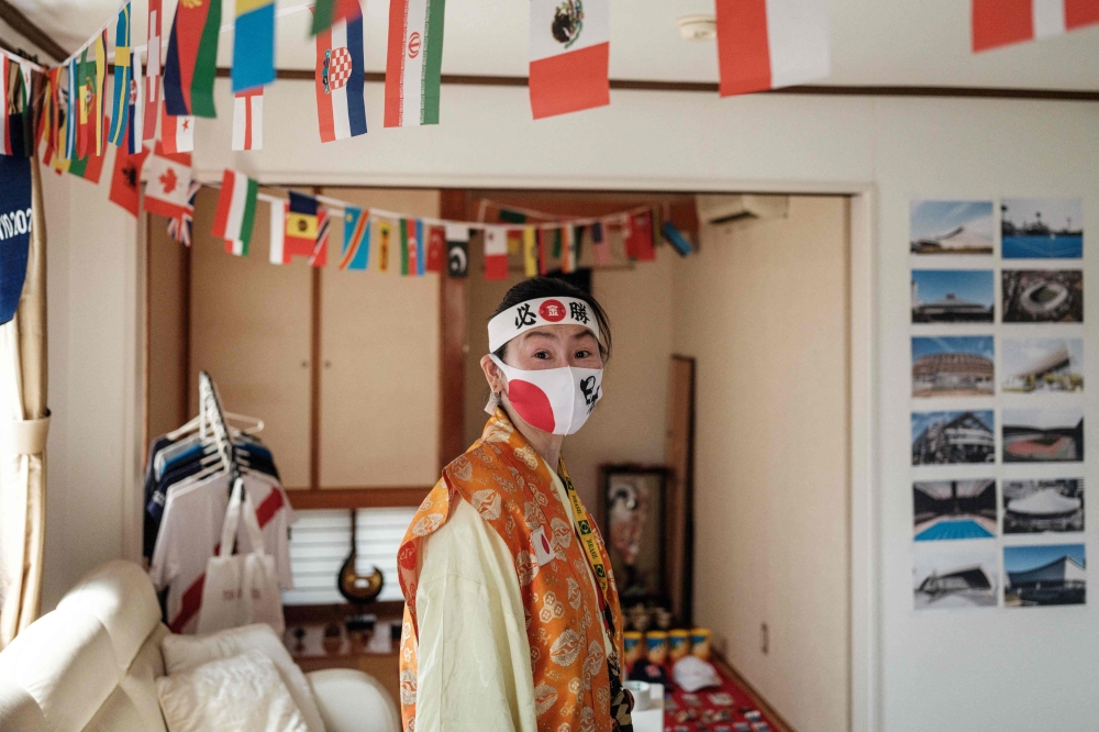 Olympic super-fan Kyoko Ishikawa, who has attended every Summer Olympics in the past 30 years,  poses after decorating her home in Tokyo. -- AFP