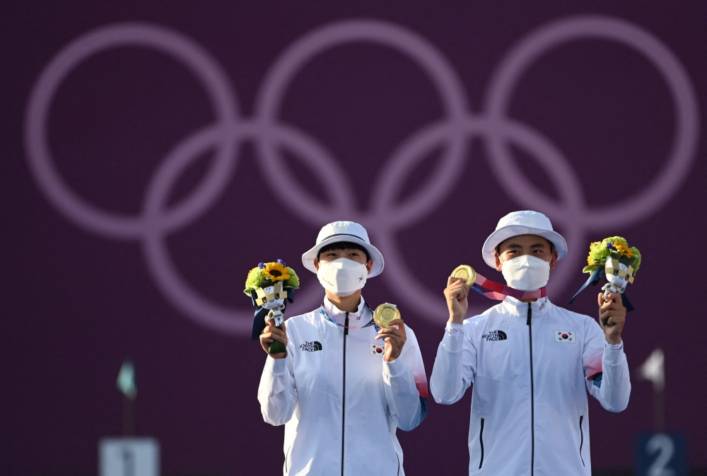 Gold medallists South Korea's An San and Kim Je-doek pose during the mixed team victory ceremony during the Tokyo 2020 Olympic Games at Yumenoshima Park Archery Field in Tokyo on July 24, 2021. 

