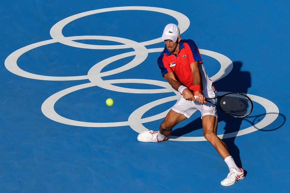 Serbia's Novak Djokovic returns a shot to Bolivia's Hugo Dellien during their Tokyo 2020 Olympic Games men's singles first round tennis match at the Ariake Tennis Park in Tokyo on July 24, 2021. 
