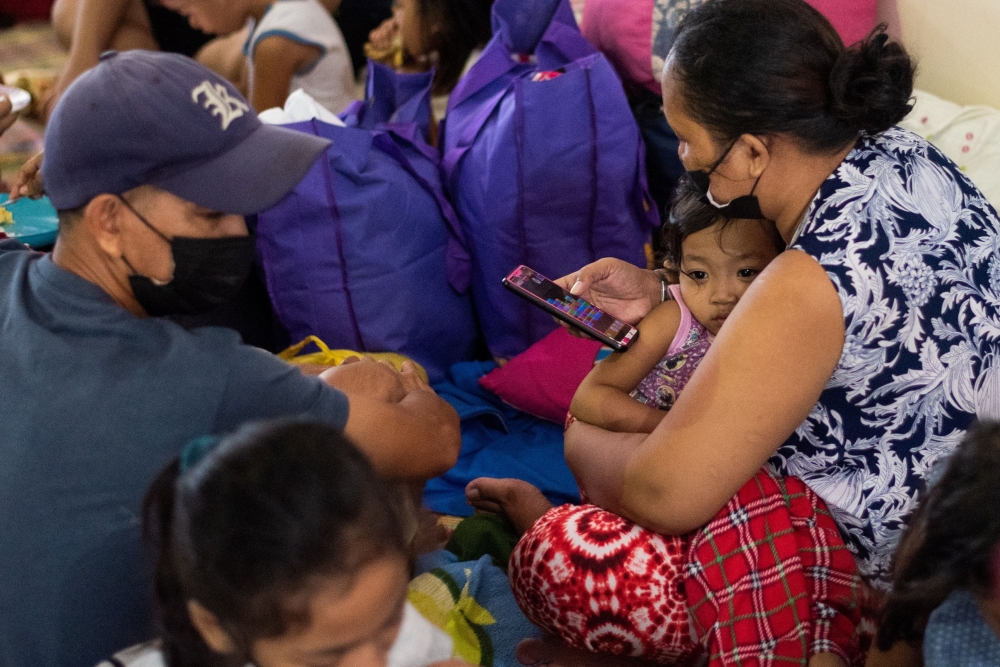 A child leans on her mother after being evacuated at a school following heavy rains that caused flooding in some areas in Marikina city, Metro Manila, Philippines, July 24, 2021. REUTERS/Lisa Marie David
