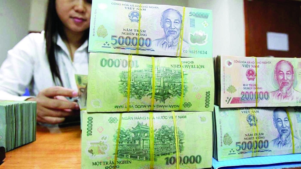 A clerk counts Vietnamese dong banknotes at a bank in Hanoi. — Reuters