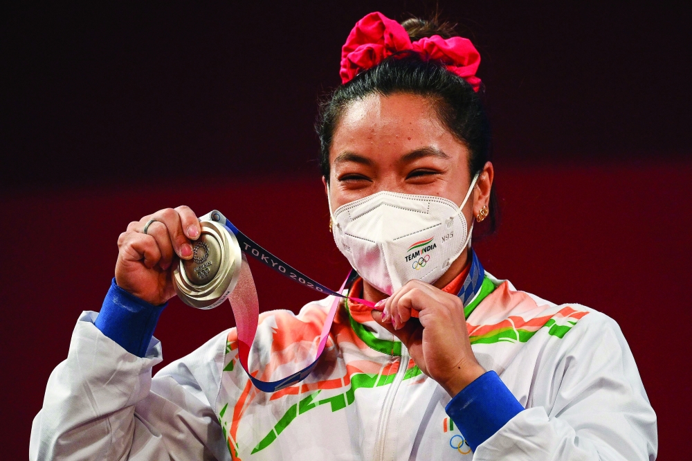 Silver medallist India's Chanu Saikhom Mirabai stands on the podium for the victory ceremony of the women's 49kg weightlifting competition during the Tokyo 2020 Olympic Games at the Tokyo International Forum in Tokyo. -- AFP