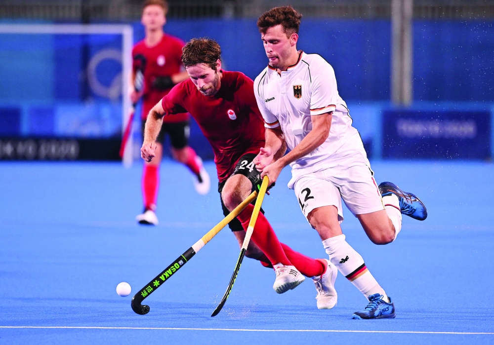 Canada's James Alexander Paget Kirkpatrick (L) and Germany's Timm Alexander Herzbruch vie for the ball. -- AFP