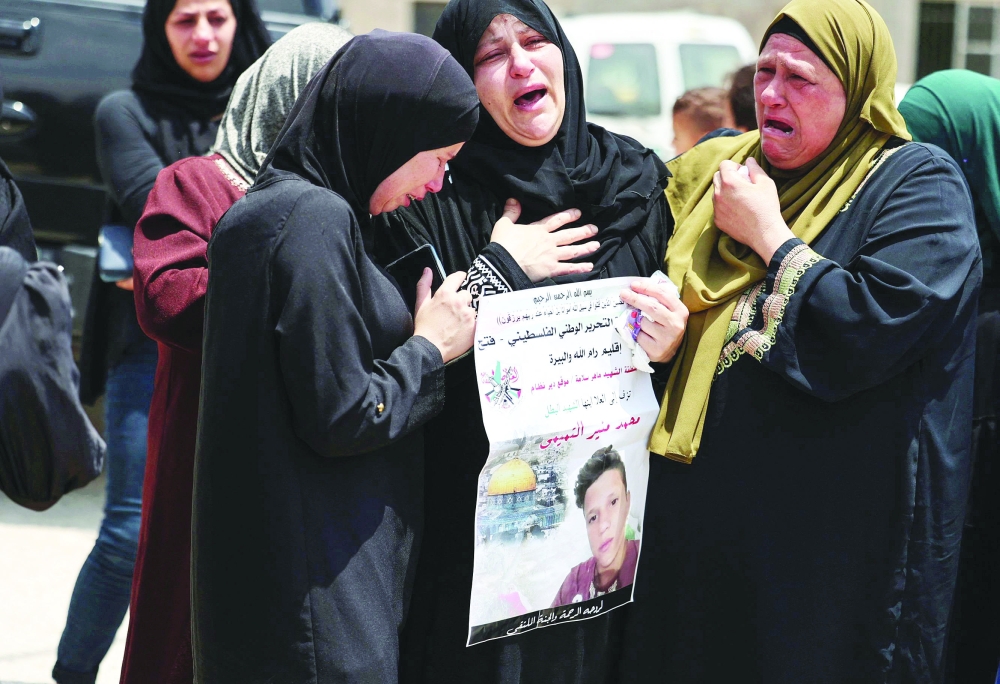 Relatives comfort Ruba al Tamimi as she mourns her son Muhammad during his funeral procession in Deir Nizam, west of Ramallah city in the occupied West Bank, on  Saturday. - AFP