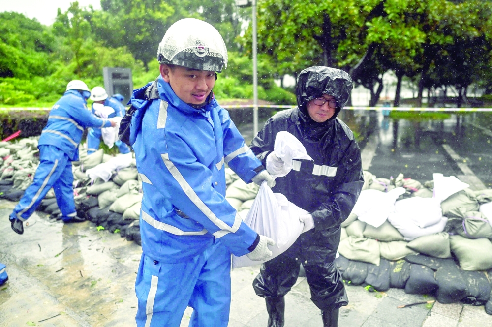 A team puts sandbags next to the Yuyao river in Ningbo, eastern Zhejiang province as Typhoon In-Fa lashes the eastern coast of China. - AFP 