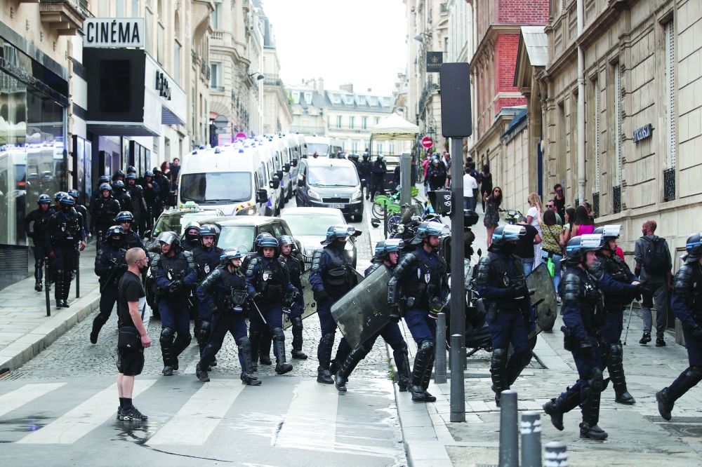 Police forces walk on the Champs Elysees Avenue after clashes on the sidelines of a demonstration against France's restrictions to fight the coronavirus disease outbreak in Paris. - Reuters