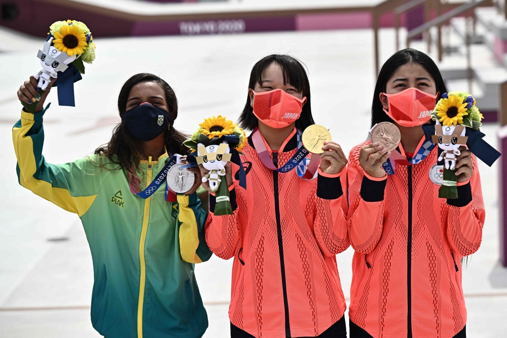(LtoR) Brazil's Rayssa Leal (silver), Japan's Momiji Nishiya (gold), and Japan's Funa Nakayama (bronze) pose during the medal ceremony of the podium ceremony of the skateboarding women's street final of the Tokyo 2020 Olympic Games at Ariake Sports Park in Tokyo on July 26, 2021.  