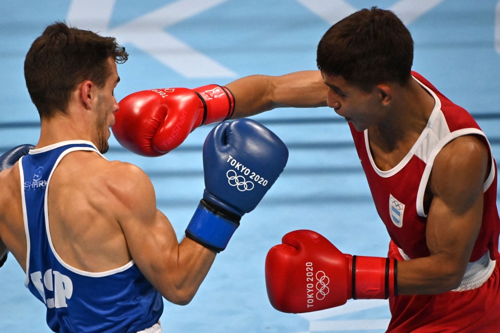 Argentina's Ramon Nicanor Quiroga (red) and Spain's Gabriel Escobar Mascunano fight during their men's fly (48-52kg) preliminaries boxing match during the Tokyo 2020 Olympic Games at the Kokugikan Arena in Tokyo on July 26, 2021.  