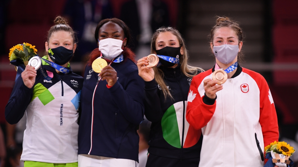 Tokyo 2020 Olympics - Judo - Women's 63kg - Medal Ceremony - Nippon Budokan - Tokyo, Japan - July 27, 2021. Gold medallist Clarisse Agbegnenou of France, silver medallist Tina Trstenjak of Slovenia, bronze medallist Maria Centracchio of Italy, and bronze medallist Catherine Beauchemin-Pinard of Canada wearing protective face masks pose with their medals 
