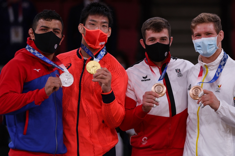 Silver medallist Mongolia's Saeid Mollaei, gold medallist Japan's Takanori Nagase and bronze medallists Austria's Shamil Borchashvili and Belgium's Matthias Casse celebrate during the medal ceremony for the judo men's -81kg contest during the Tokyo 2020 Olympic Games at the Nippon Budokan in Tokyo on July 27, 2021. 