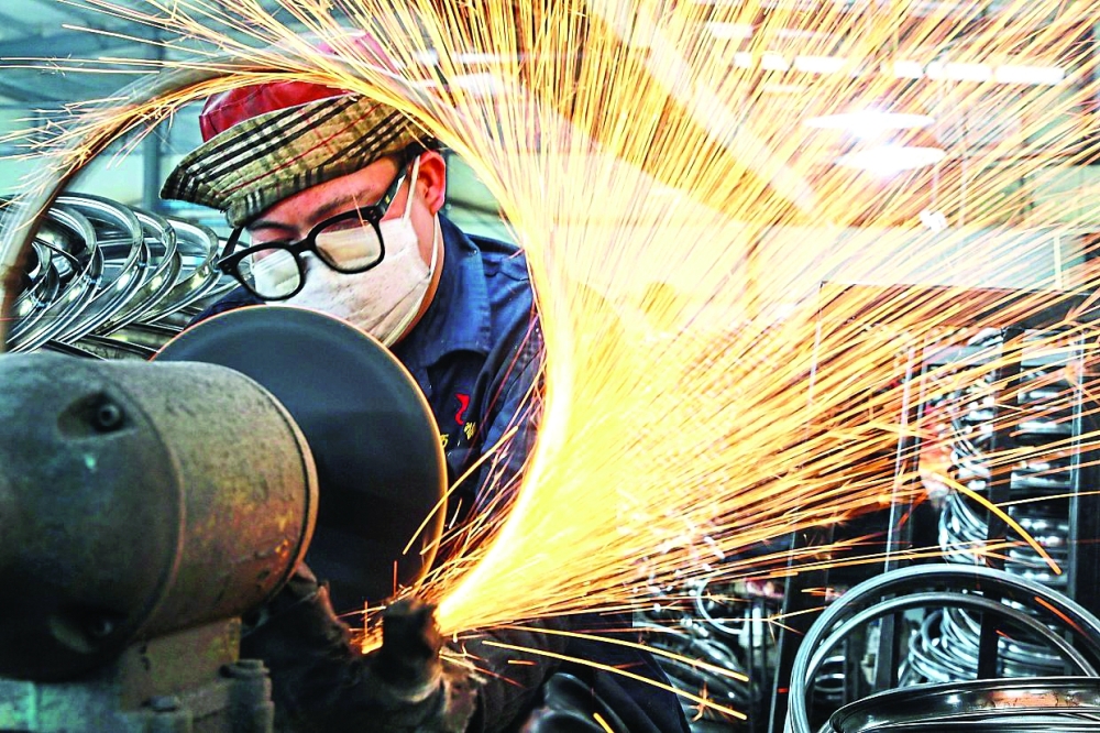A worker welds wheels at a factory in Hangzhou in China's eastern Zhejiang province, China. — AFP