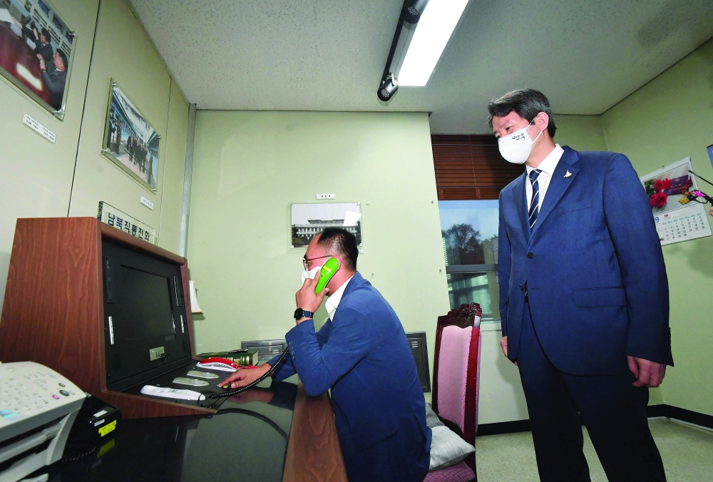 This file photo taken on September 16, 2020 shows South Korea's Unification Minister Lee In-young (R) looking at the inter-Korean "hotline" during a visit to the south side of the truce village of Panmunjom in the Demilitarized Zone (DMZ) dividing the two Koreas. - AFP  