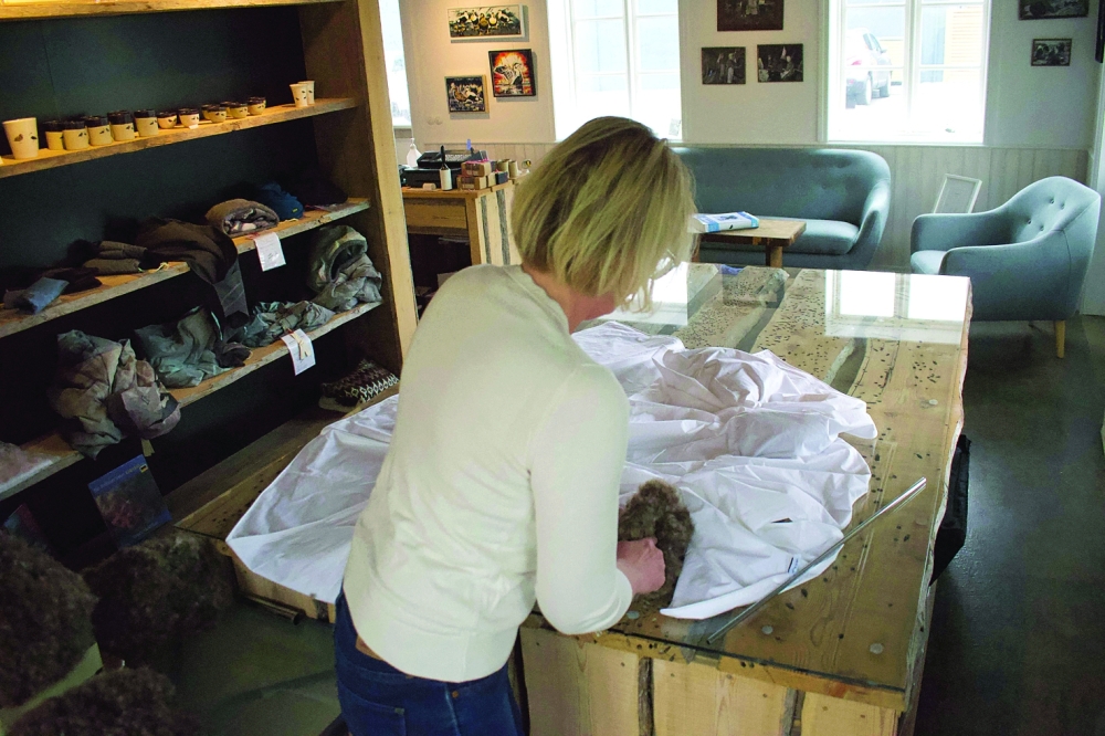 Owner and manager of King Eider, Erla Fridriksdottir fills a duvet with eiderdown at at her company in Stykkisholmur, Iceland, on July 5, 2021. On a remote island in Breidafjordur Bay off the west coast of Iceland, a thousand-year-old harvest takes place, a hunt for elusive eiderdown, which is used to make some of the world's best duvets and quilts. The handpicked down sells for thousands of euros a kilogram, catering to those looking for exclusive products.