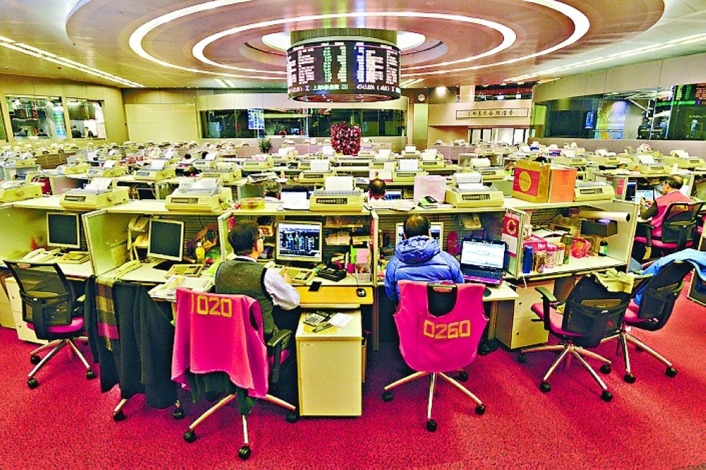 Floor traders work during afternoon trading at the Hong Kong Stock Exchange, in Hong Kong. — Reuters 