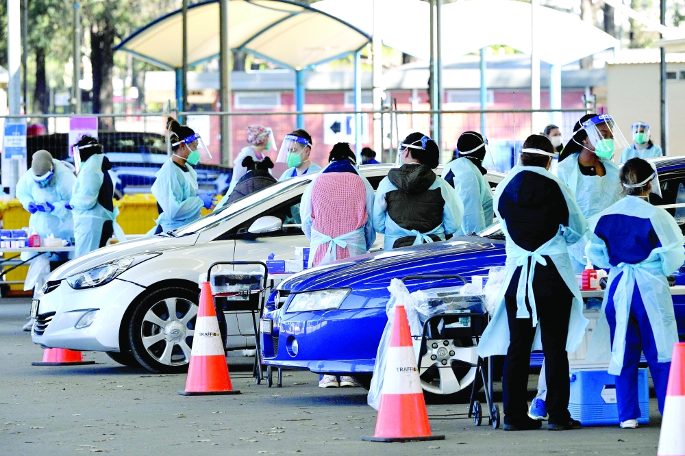 Health workers take swab samples from residents at a Covid-19 drive-through testing clinic in Sydney on Wednesday. - AFP