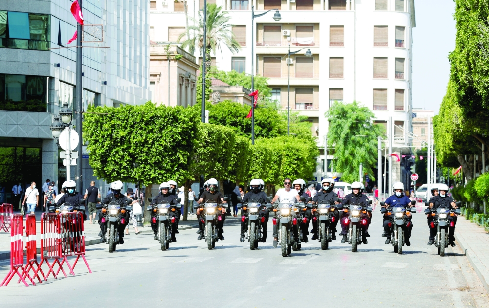 Police officers patrol a street in Tunis on Wednesday. - Reuters