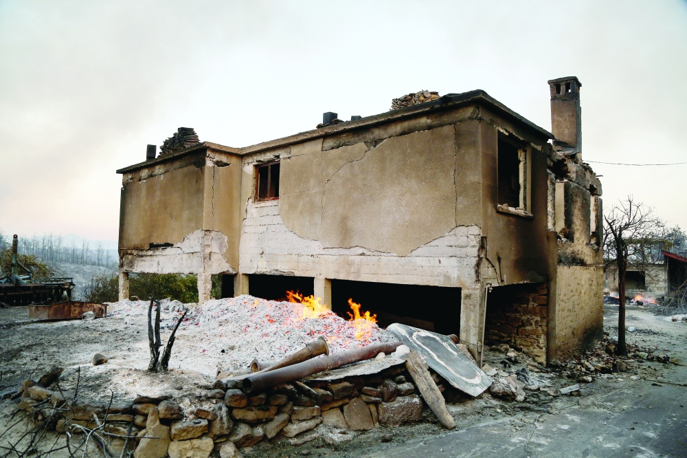 A burnt house is seen as a massive forest fire spread to the town of Manavgat, 75 km east of the resort city of Antalya. - Reuters